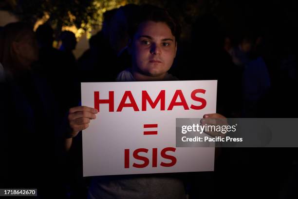 Protester holding a placard in support to Israel during the torchlight procession organized by the newspaper 'Il Foglio' at the Arco di Tito, after...