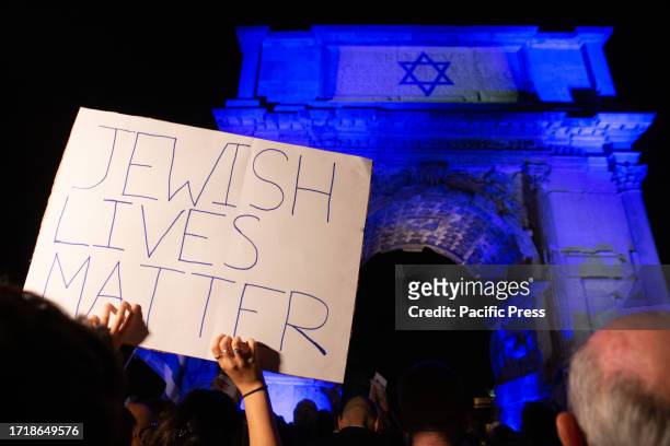 Protester holding a placard in support to Israel during the torchlight procession organized by the newspaper 'Il Foglio' at the Arco di Tito, after...
