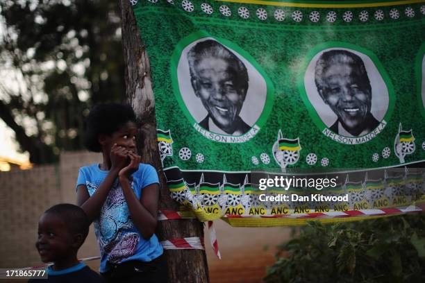 Girl stands besides an ANC flag depicting Nelson Mandela outside the MediClinic Heart hospital where former South African President Nelson Mandela is...