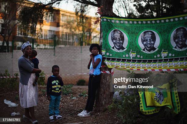 Girl stands besides an ANC flag depicting Nelson Mandela outside the MediClinic Heart hospital where former South African President Nelson Mandela is...