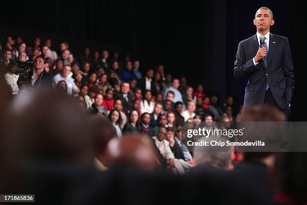 President Barack Obama takes questions from the audience and from people in Nigeria, Uganda and Kenya via live link during a "town hall" meeting with...