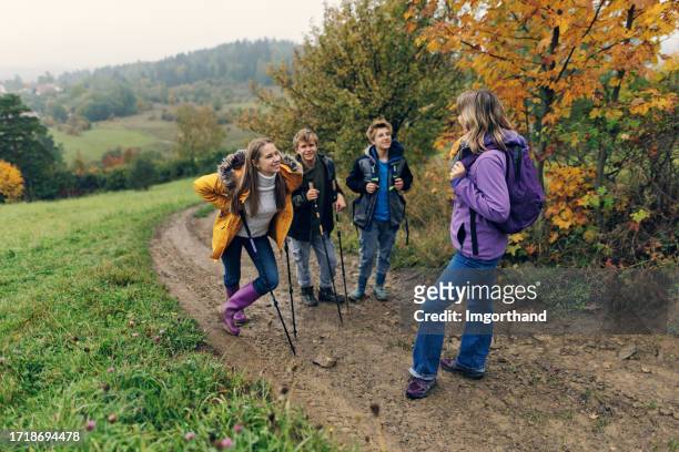 mother and three teenagers hiking in hills on a rainy day. - 12 17 months stock pictures, royalty-free photos & images