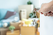 Moving house, relocation. Man hold key house keychain in new apartment. move in new home. Buy or rent real estate. flat tenancy, leasehold property, new landlord, investment, dwelling, loan, mortgage