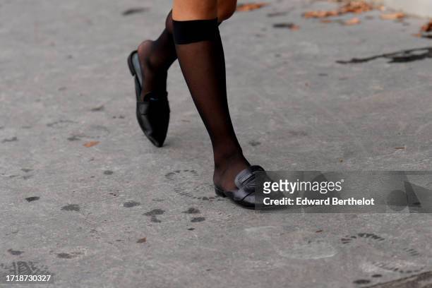 Guest wears black short tights, black leather Prada shoes, outside Chanel, during the Womenswear Spring/Summer 2024 as part of Paris Fashion Week on...