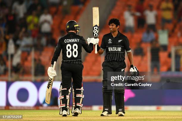 Rachin Ravindra of New Zealand celebrates their century with team mate Devon Conway during the ICC Men's Cricket World Cup India 2023 between England...