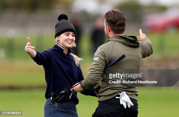 Actress, Kathryn Newton embraces playing partner Connor Syme of Scotland on the 18th green during Day One of the Alfred Dunhill Links Championship at...