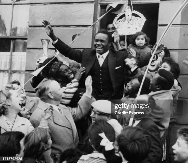 Nigerian-British featherweight boxer Hogan Bassey is congratulated by his neighbours after returning to his home in Liverpool, Merseyside, England,...