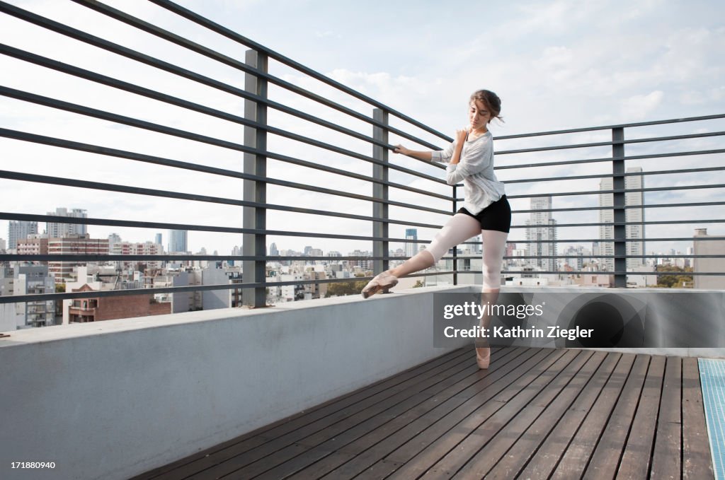 Ballerina in pointe shoes exercising on sun deck