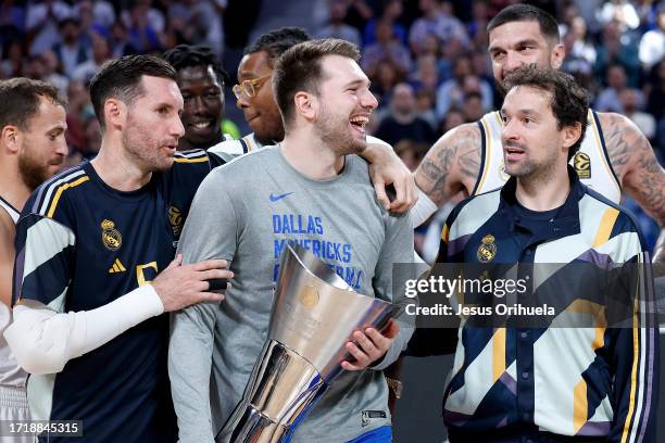 Rudy Fernandez, #5 of Real Madrid and Sergio Llull, #23 of Real Madrid give the Euroleague Basketball trophy, that won by Real Madrid with Luka...