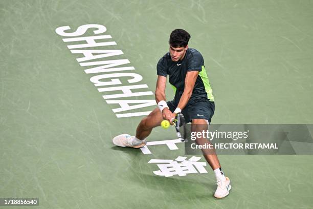 Spain's Carlos Alcaraz hits a return to Bulgaria's Grigor Dimitrov during their men's singles match at the Shanghai Masters tennis tournament in...