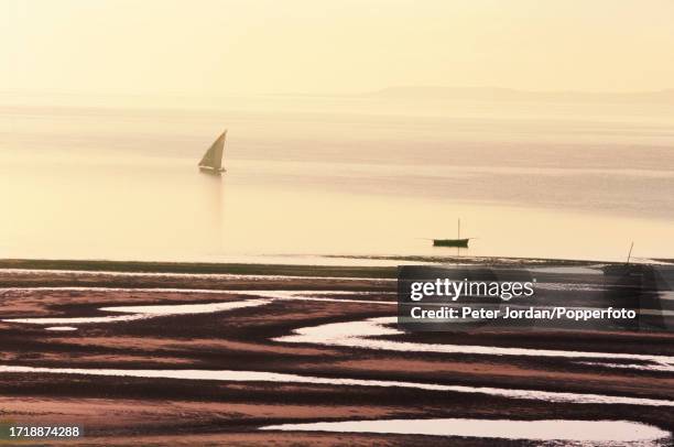 Wooden dhow sails on the waters of the Indian Ocean off the beach of the coastal town of Vilankulo in Inhambane Province of Mozambique in Southern...