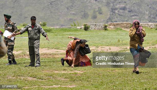 An old lady trying to maintain the balance as IAF helicopter deboarded at Joshimath helipad on June 29, 2013 in Joshimath, India. Continuous...