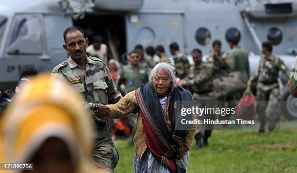 Army personnel helping an old lady after rescued from Badrinath at Joshimath helipad on June 29, 2013 in Joshimath, India. Continuous helicopter...