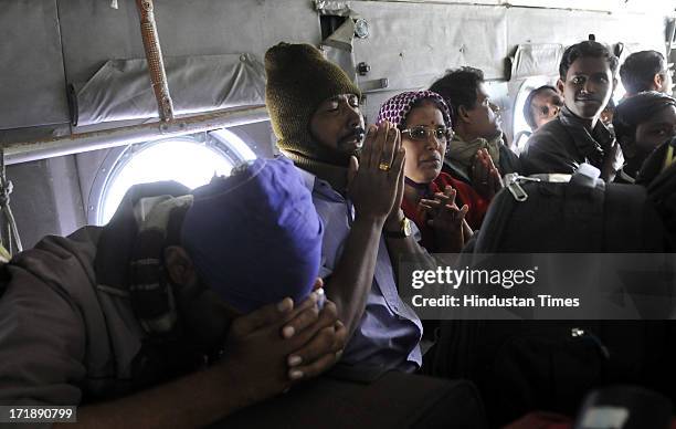 Pilgrims praying as coming back to Joshimath by IAF helicopter after being stranded for weeks at Badrinath on June 29, 2013 in Joshimath, India....