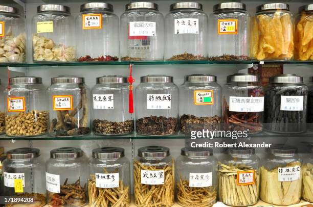 Glass canisters filled with exotic herbs and animal products, including deer antlers, ginseng and tangerine peelings, line shelves in a shop in the...