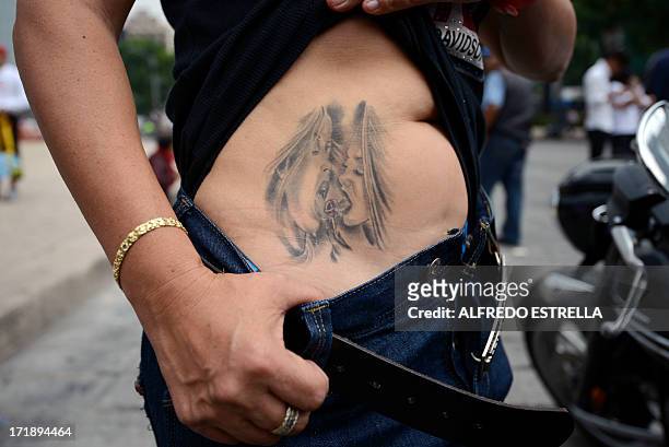 Woman shows off a tattoo during the 35th Gay Pride Parade along Reforma Avenue in Mexico City on June 29, 2013. AFP PHOTO/Alfredo Estrella