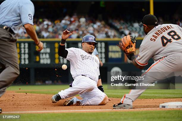 Yorvit Torrealba of the Colorado Rockies slides safely into third base against Pablo Sandoval of the San Francisco Giants during the game at Coors...