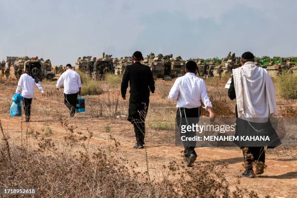 Ultra-Orthodox Jews visit Israeli army soldiers to show their support as they deploy at a position near the border with Gaza in southern Israel on...