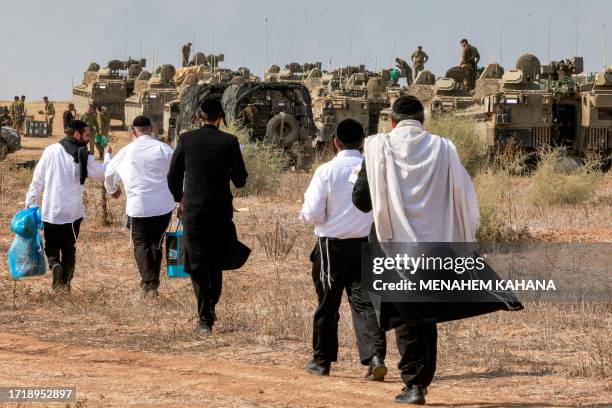 Ultra-Orthodox Jews visit Israeli army soldiers to show their support as they deploy at a position near the border with Gaza in southern Israel on...