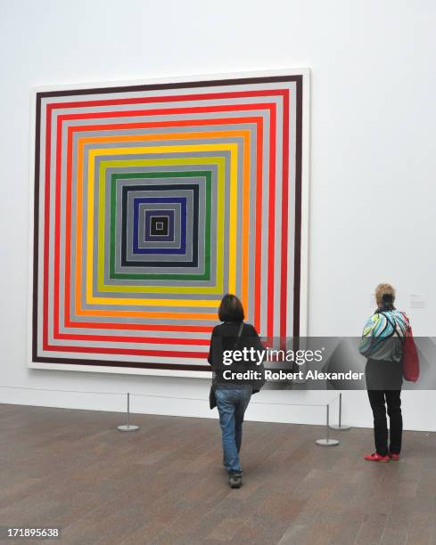 Visitors admire a painting by Frank Stella on display at the de Young Museum, also known as the M.H. De Young Memorial Museum, in San Francisco,...