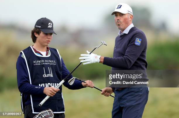 Matt Kuchar of The United States takes his putter from his son after his second shot on the second hole during the first round of the Alfred Dunhill...