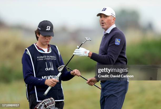 Matt Kuchar of The United States takes his putter from his son after his second shot on the second hole during the first round of the Alfred Dunhill...