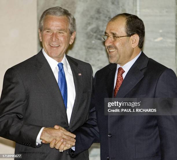 President George W. Bush greets Iraqi Prime Minister Nouri al-Maliki Baghdad inside the US Embassy during an unannounced five-hour trip 13 June 2006,...
