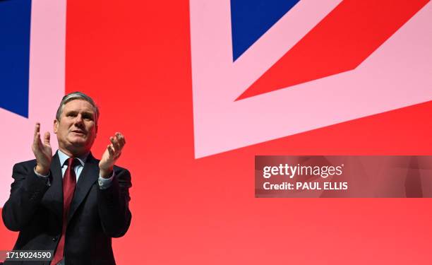 Britain's main opposition Labour Party leader Keir Starmer applauds a speaker the final day of the annual Labour Party conference in Liverpool,...