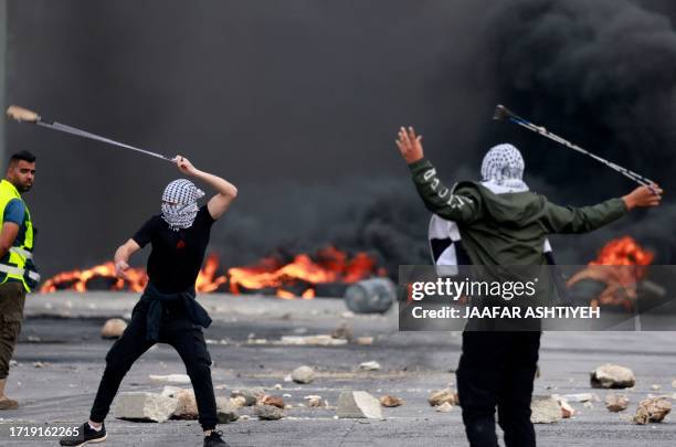 Palestinians hurl stones at Israeli forces during a demonstration against Israli bombardment of the Gaza strip, in the city of Ramallah in the...