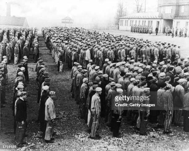 High-angle view of Polish prisoners in striped uniforms standing in rows before Nazi officers at the Buchenwald Concentration Camp, Weimar, Germany,...