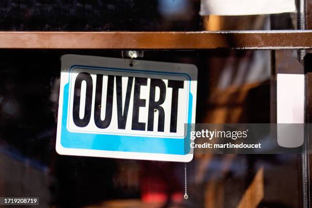 storefront sign open in french ouvert. - opening hours sign stock pictures, royalty-free photos & images