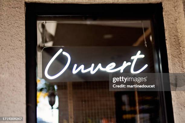 storefront sign open in french ouvert. - opening hours sign stock pictures, royalty-free photos & images