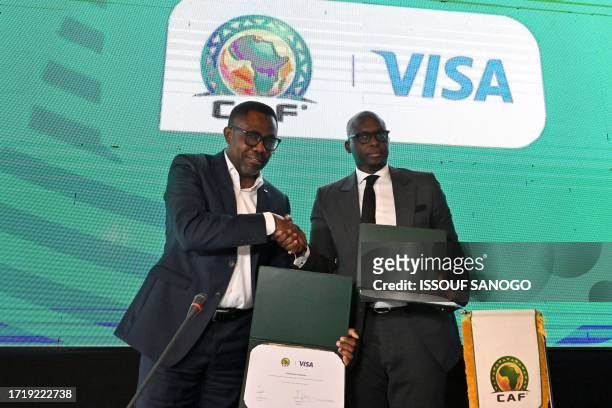 General Secretary Veron Mosengo-Omba and VISA regional director for West Africa and Central Africa Ismahill Diaby shake hands during the...