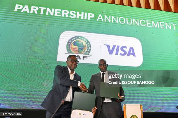 General Secretary Veron Mosengo-Omba and VISA regional director for West Africa and Central Africa Ismahill Diaby shake hands during the...