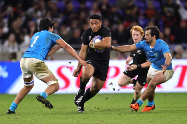 Caleb Clarke of New Zealand is challenged by Lucas Bianchi and Manuel Ardao of Uruguay during the Rugby World Cup France 2023 match between New...