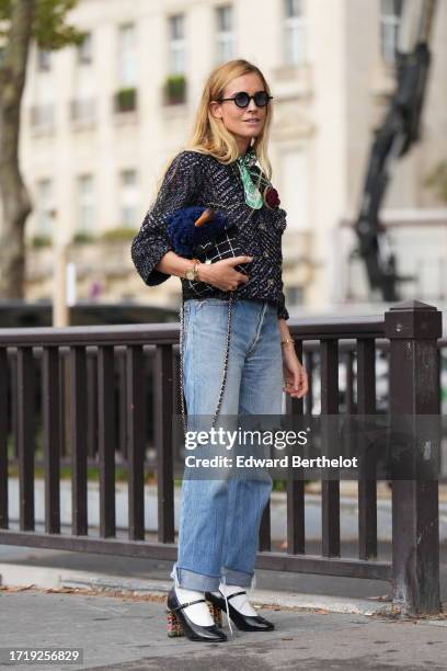 Blanca Miro wears sunglasses, a green scarf, a tweed knit jacket, a black striped Chanel bag, ripped jeans, white socks, high heels shoes, outside...
