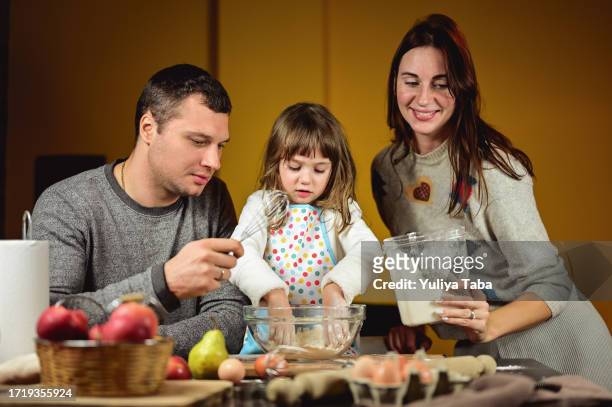 young family learning daughter cooking a pie. - italian mother kitchen stock pictures, royalty-free photos & images