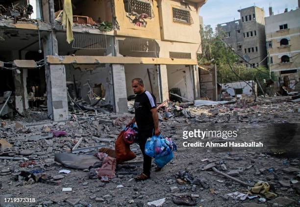 Palestinian citizens inspect damage to their homes caused by Israeli airstrikes in the Karama area, northern Gaza Strip October 11, 2023 in Gaza...