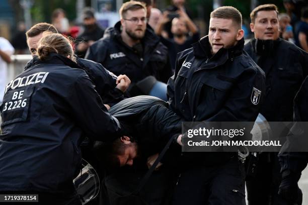 Riot police officers bring a pro-Palestinian demonstrator into a police van at Herrmannplatz, Berlin on October 11 as pro-Palestinian gatherings took...