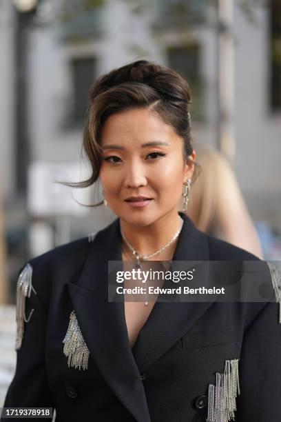 Ashley Park wears earrings, a necklace, a black oversized blazer jacket with mini chain fringe details, outside Stella McCartney, during the...