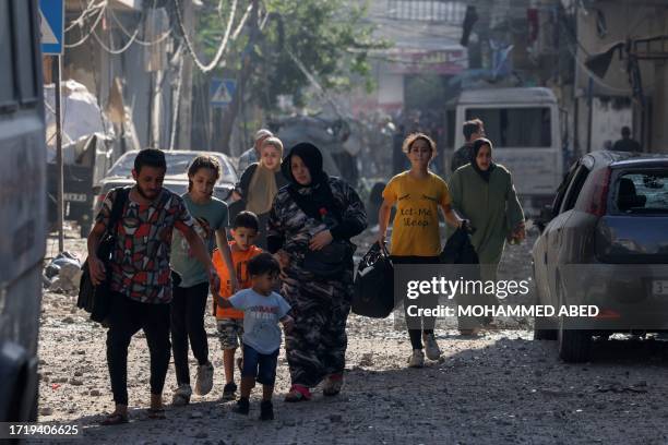 Graphic content / Palestinians evacuate a neighbourhood in Gaza City on October 11 as raging battles between Israel and the Hamas movement continue...