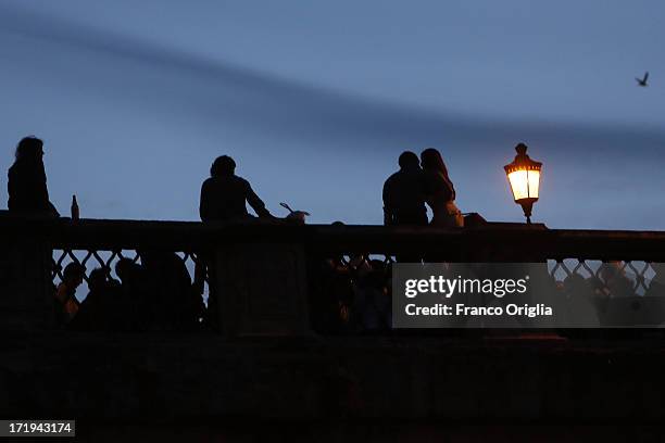 People gather on the Ponte Sant'Angelo over the Tiber to wait for the traditional 'La Girandola' fireworks over Castel Sant'Angelo on June 29, 2013...