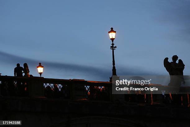 People gather on the Ponte Sant'Angelo over the Tiber to wait for the traditional 'La Girandola' fireworks over Castel Sant'Angelo on June 29, 2013...
