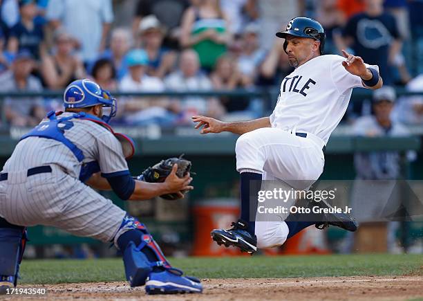 Raul Ibanez of the Seattle Mariners slides into home against catcher Welington Castillo of the Chicago Cubs while trying to score on a single by...