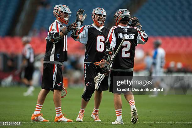 Terry Kimener, Jeremy Boltus and Brendan Mundorf of the Denver Outlaws celebrate a first half goal against the Charlotte Hounds during a Major League...