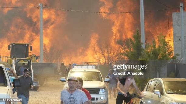 People run away from the rising and approaching flames of wildfire broke out in the resort city of Villa Carlos Paz, Cordoba, Argentina on October...