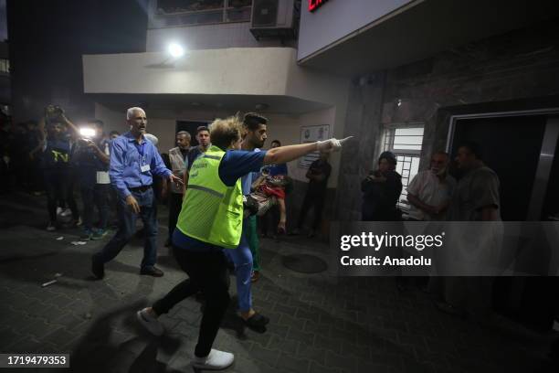 Medical staff help injured people to bring to Al-Shifa Hospital, in Gaza City, Gaza as Israel's attacks on the Gaza Strip continue on its fifth day...