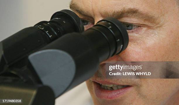 Britain's Prime Minister Tony Blair looks through a microscope at a leukemia infected blood sample in the Blood Science Laboratory in Kings College...