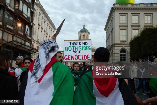 Demonstrator holds a sign that reads 'There's no both sides to a genocide' during a demonstration in support of Palestine in Mont des Arts on October...