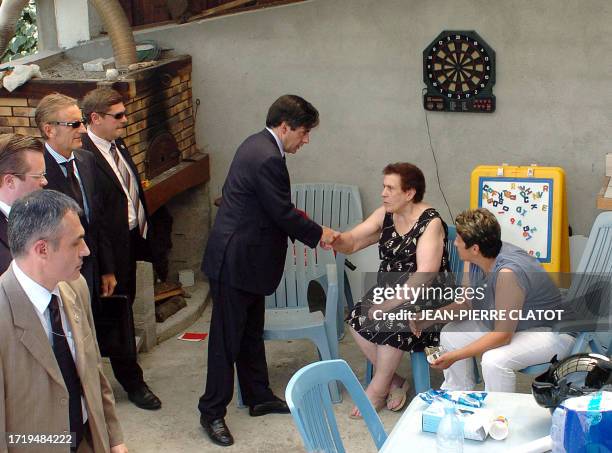 French Prime Minister François Fillon shakes hands with a neighbour of the coach accident, 22 July 2007 in Vizille, where a coach carrying Polish...